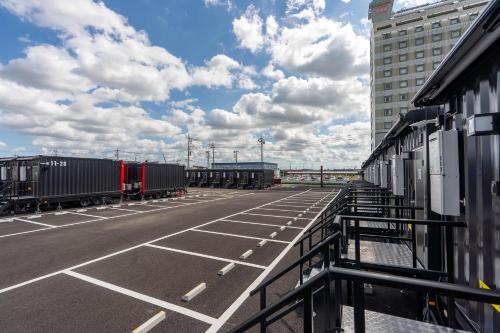 an empty parking lot with cars and a building at HOTEL R9 The Yard Kasama in Tomobe