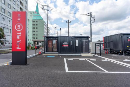 a parking lot with a bus stop in a city at HOTEL R9 The Yard Kasama in Tomobe