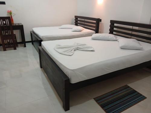 two beds in a room with towels on them at Yala Thaman in Kataragama