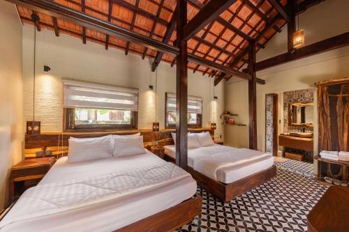 a bedroom with two beds and a bathroom at Sun Village in Tuy Hoa
