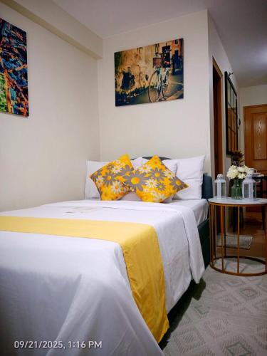 a bedroom with a bed with yellow and white sheets at Norman Condominium Unit Rental in Dumaguete