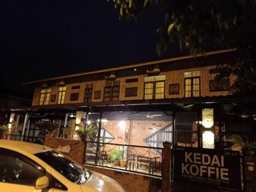 a yellow car parked in front of a building at Rareheart Guesthouse in Kuala Terengganu