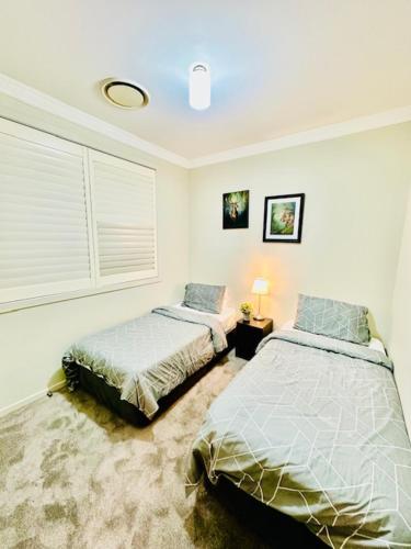 a bedroom with two beds and a window at Entire 4 Bed Rooms Sanctuary in West Hoxton