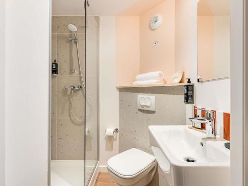 ein Badezimmer mit Toilette, Waschbecken und Dusche in der Unterkunft greet Hôtel Prévessin Genève Aéroport in Prévessin-Moëns
