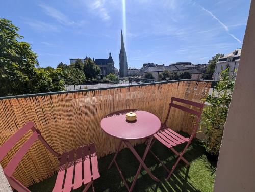 une table rose et deux chaises sur un balcon dans l'établissement Le Terra Redon - T2 tout équipé avec balcon, local vélo et gare à 6 minutes à pied, à Redon