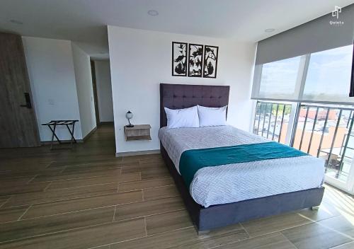 a bedroom with a bed and a large window at Quinta Park 43 in Bogotá