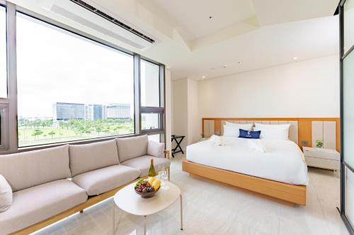 PampangThe First Clark Hotel and Residence的带床和沙发的卧室