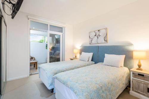 a bedroom with two beds and a window at Wharf Apartment Unit 5 in Narooma