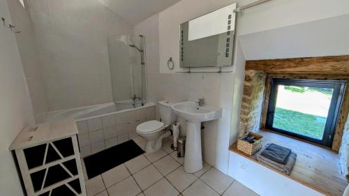 a bathroom with a sink and a toilet and a tub at Belle vue in Dournazac