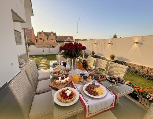 a table with breakfast food on a balcony at Villa Lumiere-Luxury Retreat with Private Spa and Garden in Ifrane