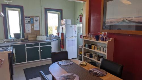 a kitchen with a table and a refrigerator at Ranfurly Green Hostel in Ranfurly