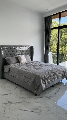 CilamaにあるKintamani Hillsの大きな窓付きのベッドルームの大型ベッド1台