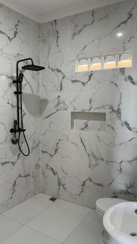 a white bathroom with a shower and a sink at Kintamani Hills in Cilama