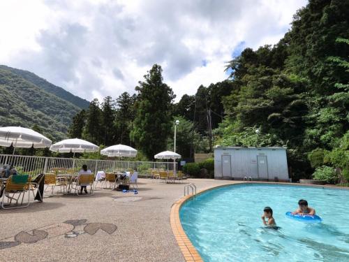a couple of people swimming in a swimming pool at Hakonenomori Okada in Hakone