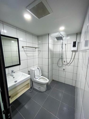a bathroom with a toilet and a sink and a shower at The 2nd Floor in Lampang