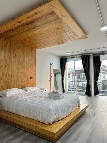 a bedroom with a large bed with a wooden headboard at The 2nd Floor in Lampang
