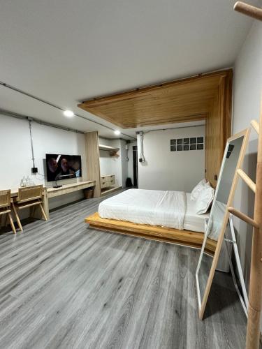 a bedroom with a bed and a flat screen tv at The 2nd Floor in Lampang