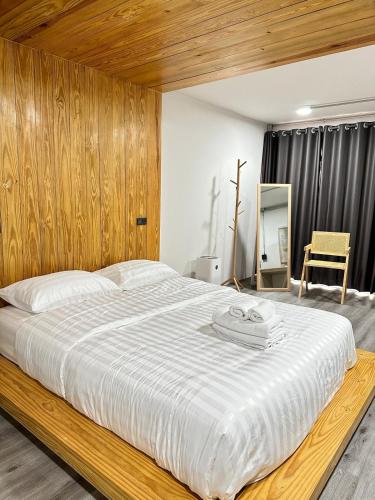 a bedroom with a large bed with a wooden headboard at The 2nd Floor in Lampang
