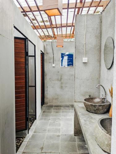 a bathroom with a stone sink and a sink at PukuPods - Tent & Cabin in Tabanan