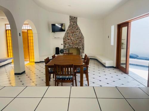 a dining room with a table and chairs and a fireplace at Casa de Playa en Lobos in Cerro Azul
