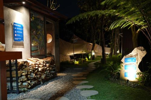 a walkway in front of a building at night at PukuPods - Tent & Cabin in Tabanan