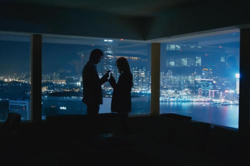 a man and a woman standing in front of a window at Upper House Hong Kong in Hong Kong