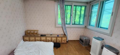 a small bedroom with a bed and a window at 누림과 섞임의 스테이 in Hoengseong