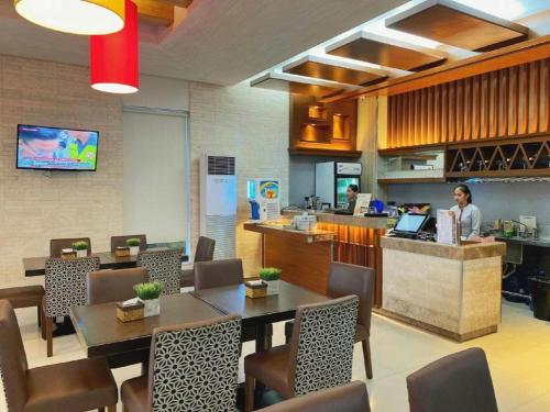 a restaurant with people working at a counter and tables at District 21 Hotel in Iloilo City