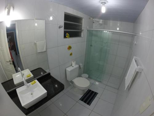 y baño con aseo, lavabo y ducha. en Pousada La Puerta Del Sol, en Porto de Galinhas