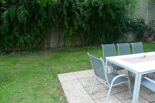 a table with four chairs and a table and a table and a grass yard at Gästehaus Haider in Illmitz