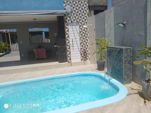 a swimming pool in front of a house at Casa com piscina e área gourmet em Arembepe in Camaçari