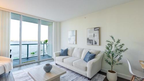 a living room with a white couch and a large window at Blue Harbour Amazing views 5 min downtown in Fort Myers