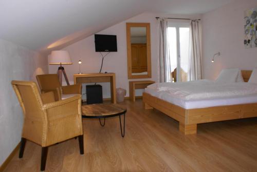 a bedroom with a bed and a table and a chair at Hotel Bad Schwarzsee in Bad-Schwarzsee