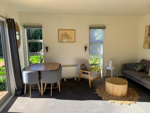 a living room with a couch and a table and chairs at Wheatstone Hideaway in Gisborne