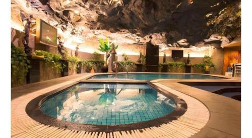 a large swimming pool in a building with a mountain at Classic Hotel in Jakarta