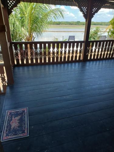 terraza con valla y vistas al agua en Rumah Kayu Homestay, en Bedung