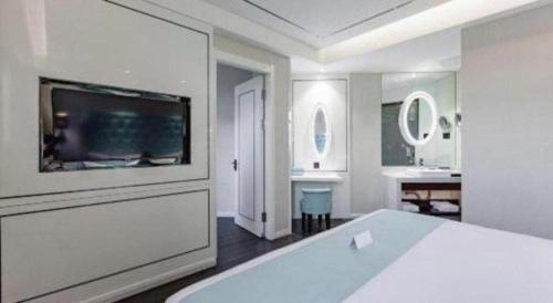 een witte slaapkamer met een groot bed en een badkamer bij Xana Lite Shenyang Beiling Park Liaoning Building Branch in Shenyang