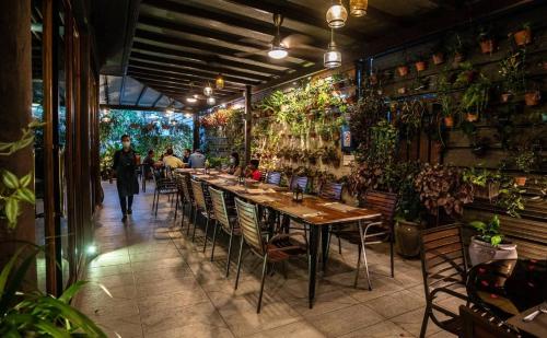 a restaurant with tables and chairs and plants on the wall at Tanjung Bungah Holiday Home 4BR 20Pax 6Carpark in Tanjung Bungah