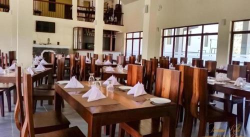 a restaurant with wooden tables and chairs with napkins on them at Talawakele Rest House in Talawakele
