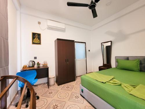 a bedroom with a green bed and a desk at Sithujaya Green Mirissa in Mirissa