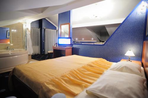 a bedroom with a large bed and a blue wall at Hotel Mozart in &Scaron;pi&scaron;ić-Bukovica