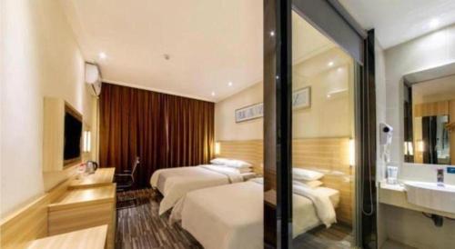 a hotel room with two beds and a sink at City Comfort Inn Guilin Two Rivers and Four Lakes Sun and Moon Shuangta in Guilin