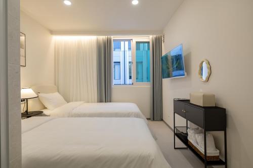 um quarto de hotel com duas camas e um espelho em MOREN Seoul Myeongdong em Seul