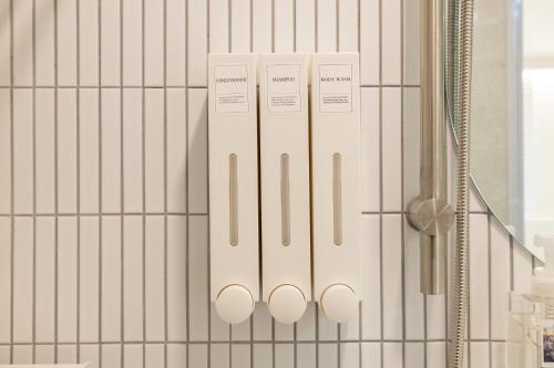 uma casa de banho com paredes em azulejos brancos e um chuveiro em MOREN Seoul Myeongdong em Seul