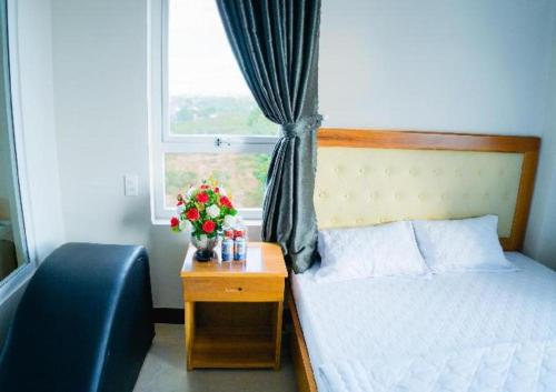 1 dormitorio con 1 cama y una ventana con flores en Hong Ha Hotel, en Pleiku Airport