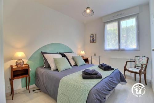 une chambre avec un lit, un bureau et une chaise dans l'établissement Le pre labas, à Péaule