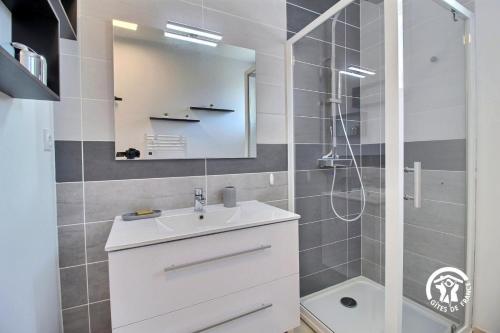une salle de bain avec un lavabo blanc et une douche dans l'établissement Le pre labas, à Péaule