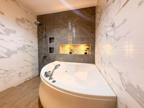 a bathroom with a tub and a sink at Pran Suk Pool Villa pranburi 