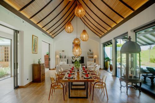 Un comedor con mesa y sillas en 4BR Laguna Golf View Pool Villa Retreats Phuket, en Laguna Phuket
