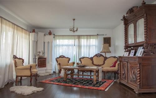 a living room with furniture and a table and chairs at Conacul Paloși in Horezu